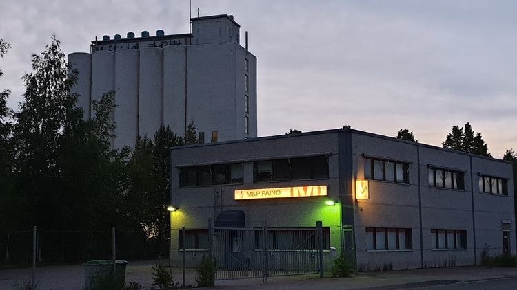 A dusky shot of a building with a sign M&P Paino